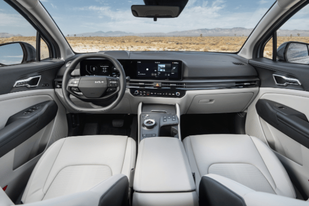 Interior del vehículo Sportage 2026, vista completa de la cabina frontal con asientos de cuero gris claro