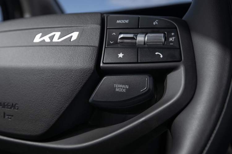 Controles del volante con el botón de modo de terreno en la parte inferior