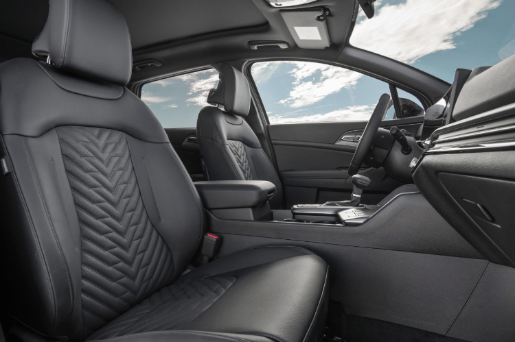 Interior del vehículo Sportage 2026, vista lateral de la cabina frontal mostrando los detalles del asiento del pasajero delantero