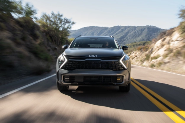 2023 Kia Sportage Plug-In Hybrid Driving Fast Down A Mountain Road Front View