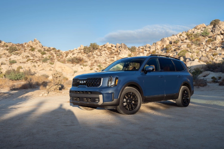 2023 Kia Telluride Parked In Front Of A House In The Desert At Sunset Rear Three-Quarter View