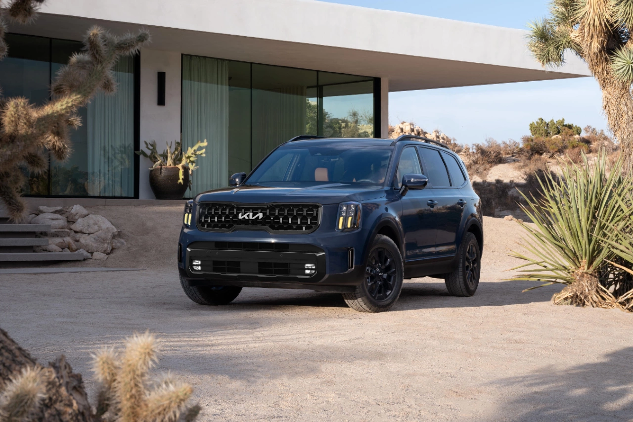 2024 Kia Telluride parked in front of a house in a desert setting