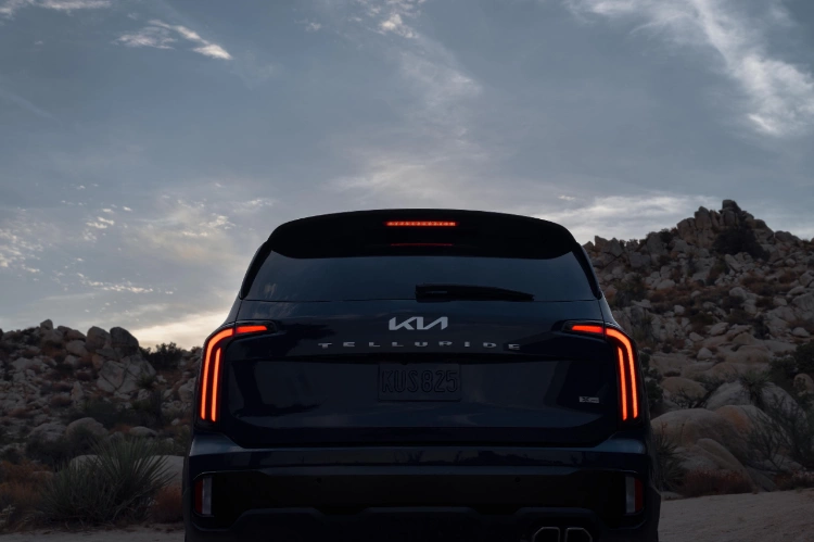 2024 Kia Telluride Parked By A Hill At Sundown With Illuminating LED Tail Lights Rear-View 