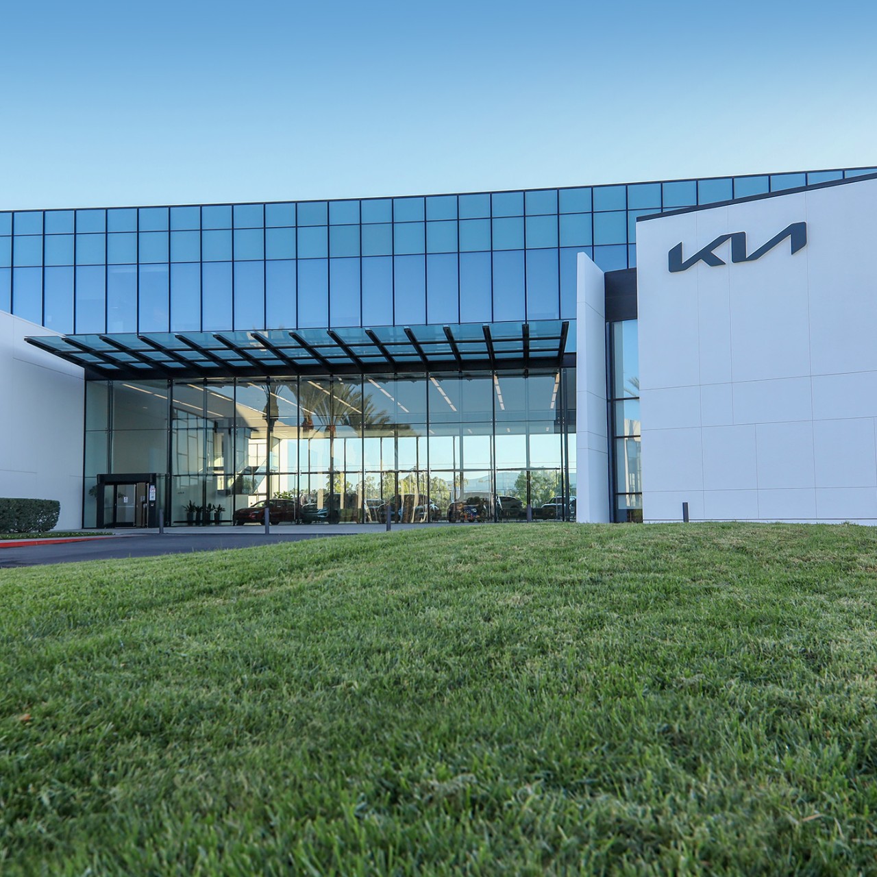 Kia America headquarters in Irvine, California: a glass corporate building with a green lush lawn.