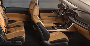 The spacious brown leather interior of a Kia vehicle.