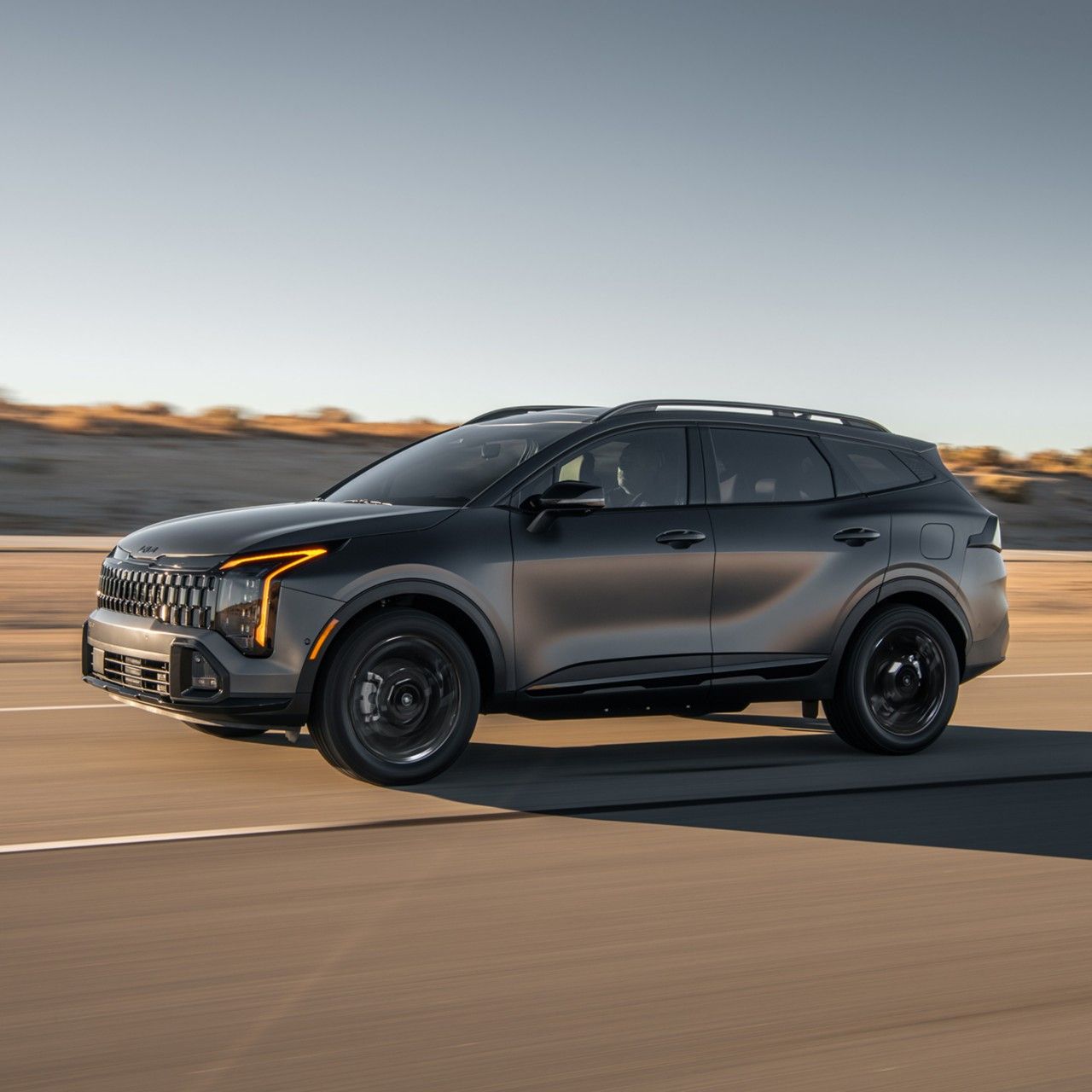 2026 Kia Sportage Plug-in Hybrid, side view, driving on a highway highlighting its sleek design