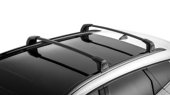 Exterior view of a white Kia SUV featuring two parallel black crossbars mounted on the roof, positioned over a panoramic sunroof. The crossbars are secured and designed for carrying cargo or accessories.
