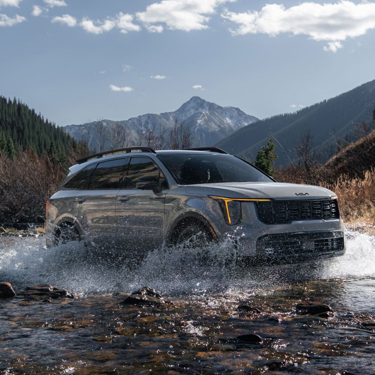 2026 Kia Sorento, vista de tres cuartos, conduciendo a través de un río haciendo una gran salpicadura