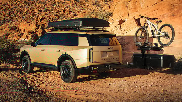 Una imagen de cerca de un sistema de entretenimiento trasero en el Kia Telluride 2027 con dos accesorios de Kia montados en reposacabezas negros.