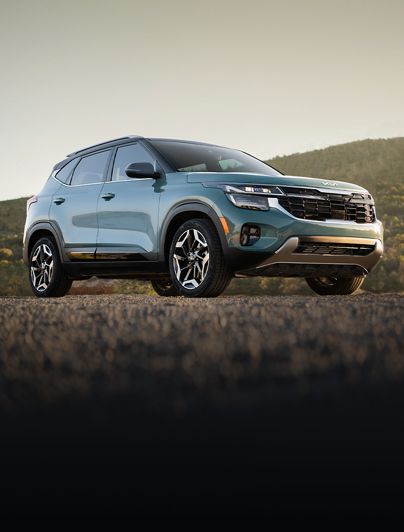 2024 Kia Seltos Parked Off-Road Near The Hills At Sunset Three-Quarter View 